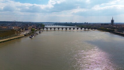 Aerial view of the Pont de Pierre bridge and Garonne River in Bordeaux France with historic waterfront and river reflections 
