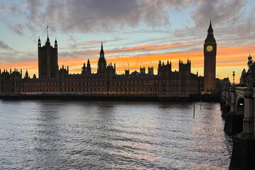London, UK - sunset over the Palace of Westminster and Elizabeth Tower (Big Ben) reflected in the River Thames