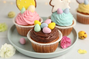 Tasty cupcakes with Easter decor on white table, closeup