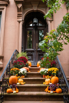 Halloween decorated brownstone stoop with pumpkins and flowers in Brooklyn, New York