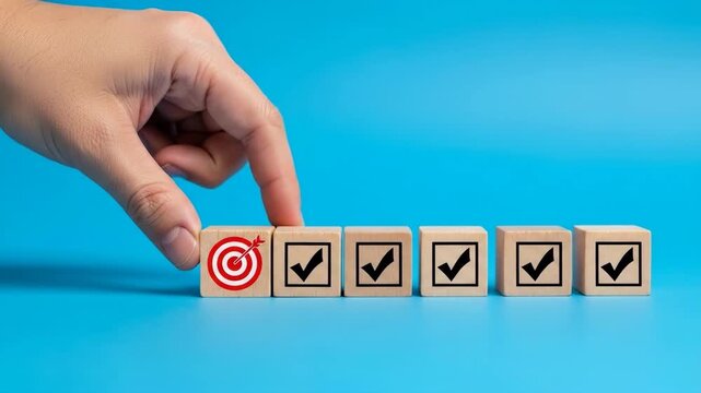 Hand Arranging Wooden Blocks with Checkmarks and Target.
