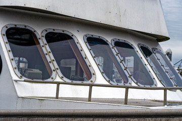 A row of bolted windows on the wheelhouse of a docked commercial fishing trawler © davidrh