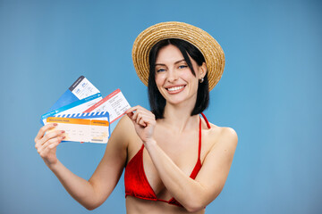 Joyful traveler holding tropical cocktail and airline tickets while celebrating upcoming vacation...