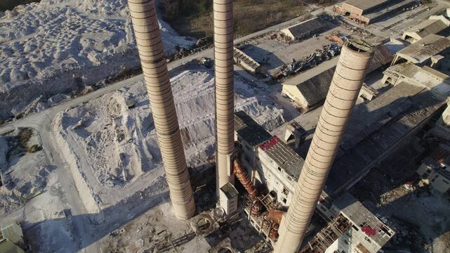  Chimneys of an old abandoned factory with vertical drone movement from the air with simultaneous tilt movement of the camera from bottom to top.
