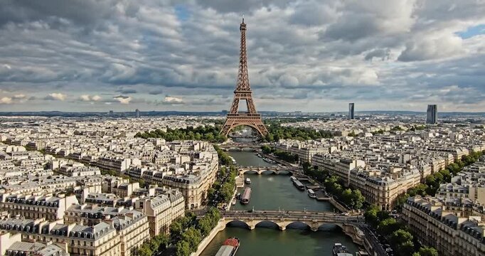 Eiffel Tower and Paris cityscape with Seine River under cloudy sky