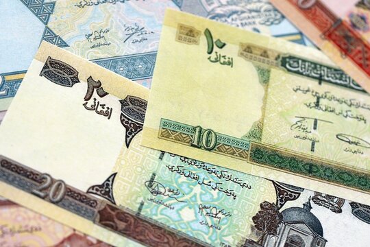 Afghan afghani paper banknotes pile on table. Afghanistan AFN currency money bills in big amount. Concept of economics, taxation and banking in Afghanistan