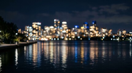 Obraz premium Blurry city skyline with colorful lights reflected on water at nighttime urban landscape
