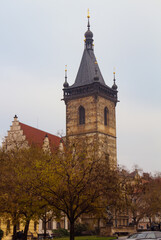 Obraz premium Old church in autumn in the city street in old Prague under blue sky