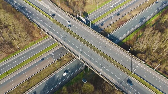 elevated highway crossing x shape ghent cars trucks moving along marked lanes to near top down aerial drone view motorway traffic road transport infrastructure transportation 