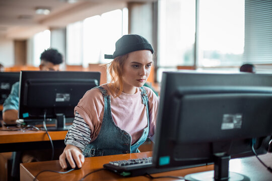 Focused student using desktop computer in university lab