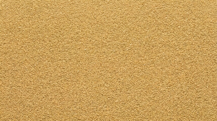 Fototapeta premium A full frame close-up shot of very fine-grained golden sand showcasing its uniform texture and warm, inviting color under natural light conditions.