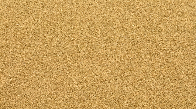 A full frame close-up shot of very fine-grained golden sand showcasing its uniform texture and warm, inviting color under natural light conditions.