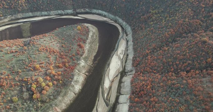 Breathtaking aerial view of mountain curved river framed by lush forested slopes