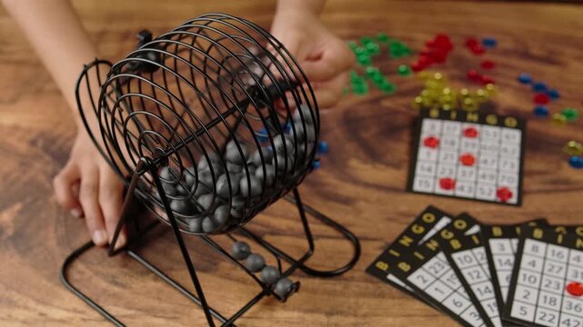 The hands of a dark skinned woman spinning the bingo wheel