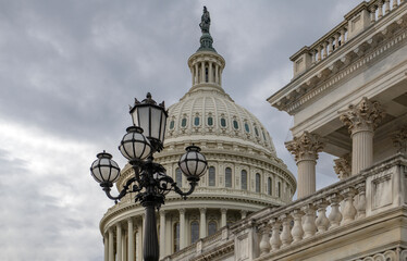 Fototapeta premium Capitol in USA government background. American Capitol on skyline in Washington DC. National Capitol with American flag in blue sky. Historic Capitol architecture on cloudy daytime.