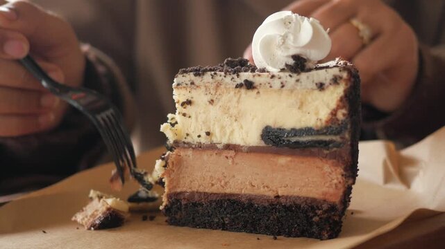 A person takes a bite of cake at a bakery in the afternoon