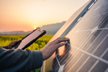 Technician inspecting solar panel with tablet in field during sunset © zhu difeng