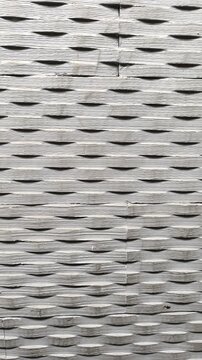 3D carved gray basalt wall tiles with chiseled horizontal oval relief and linear etched texture for architectural facades and minimalist interior designs. Vertical footage transition.