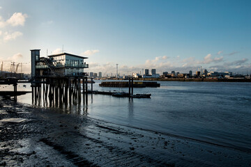 Fototapeta premium Modern stilt building on river thames at low tide