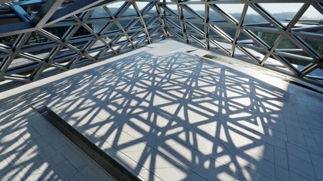 Abstract geometric patterns and shadows inside a modern architectural structure.