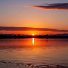 Obraz premium Serene Sunset Reflection Over Calm Waters - A Tranquil Landscape.