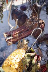 Obraz premium Hanging meat and vegetables over an open fire, the Australian bush cooking style. 