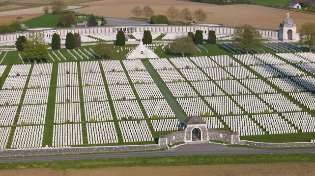 cross sacrifice aligns along green pathway bisecting thousands identical white headstones domed pavilion memorial wall stand end against muted tones surrounding far tyne cot cemetery wwi 