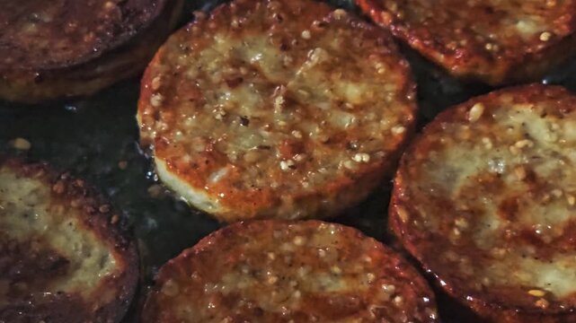 Handheld video of white pudding cooked in a pan with oil close up.