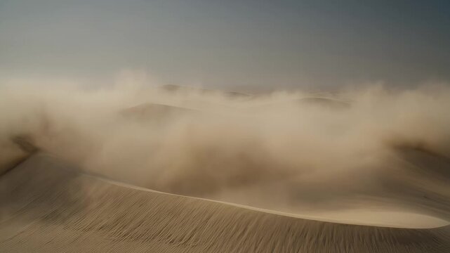 Powerful desert windstorm blowing sheets of sand across multiple dunes under a hazy sky