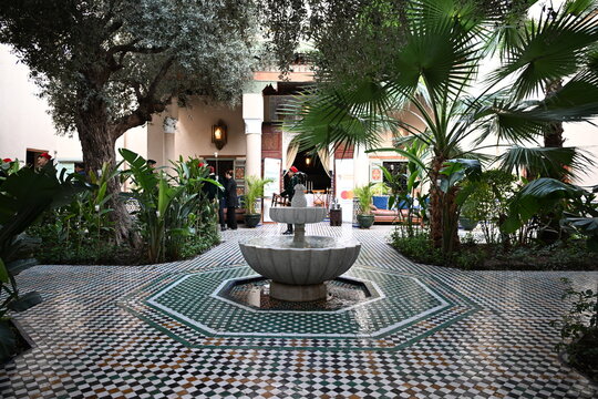 Traditional Moroccan riad entrance with ornate arch and wooden doors in Marrakech Medina