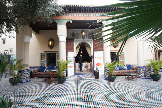 Traditional Moroccan riad entrance with ornate arch and wooden doors in Marrakech Medina