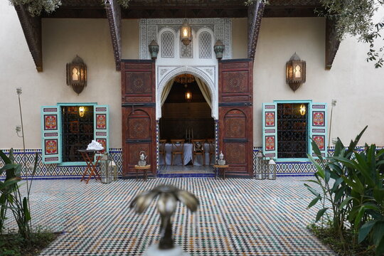 Traditional Moroccan riad entrance with ornate arch and wooden doors in Marrakech Medina