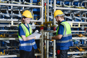 Industrial warehouse environment with Caucasian logistics workers wearing safety helmets and...