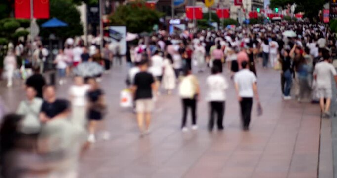 Pedestrian street in downtown Shanghai, full of passers-by, locals and domestic tourists. Shot in time-lapse mode during daytime. Blurred view to avoid recognizable faces and logos.