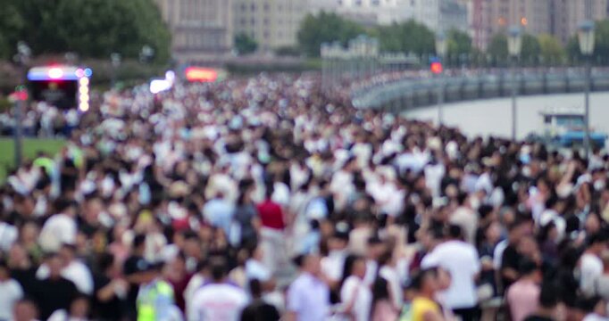 Unfocused, abstract view of massive crowd on Huangpu River embankment in Shanghai during public holiday. Dense movement of pedestrians during National Day Golden Week.