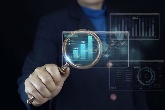 Business professional holding magnifying glass analyzing financial growth chart with rising bars from 2024 to 2026