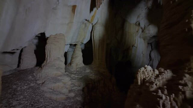 Dimly Lit Limestone Caverns Featuring Intricate Dripstone Structures And Atmospheric Geological Features