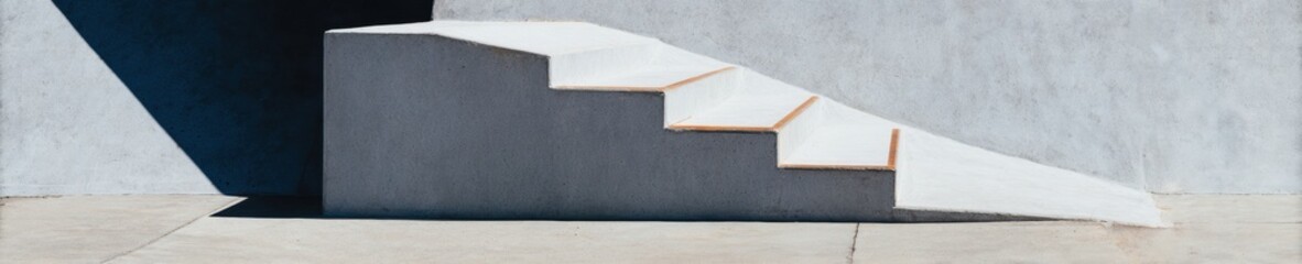 Fototapeta premium Minimalist Concrete Staircase and Ramp Structure under Bright Sunlight for Architectural Hardware Branding and Modern Urban Design Background with Copy Space