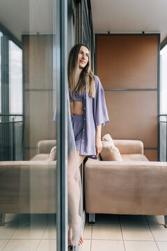 Young woman standing on modern glass balcony