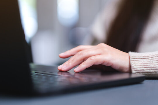Closeup image of a woman hand working and touching on laptop computer touchpad