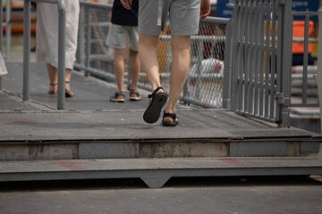Group of tourists walking up ferry pier, walking movement, walking motion, step movement, pedestrian stride, low angle, Wat Rakhang Pier. © Danchai