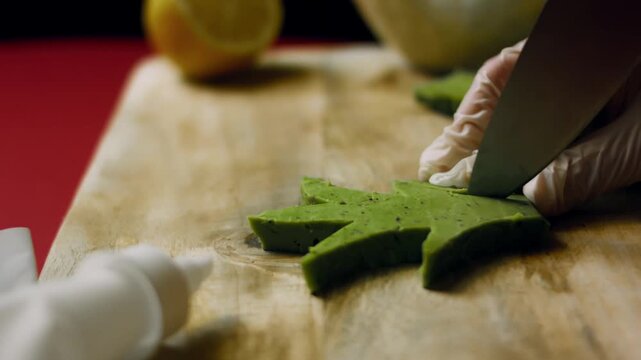 A piece of pesto cheese is cut into pineapple leaf shapes