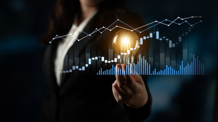 A professional woman stands confidently, holding a glowing light bulb amid vibrant graphs and data visuals, symbolizing innovation and growth in business. Scalp © InfiniteFlow