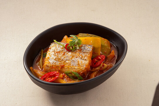 Authentic Korean Cuisine: Spicy braised cutlassfish (Galchi-jorim) with radish and chili peppers in a black bowl