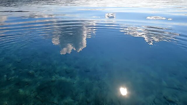 calm water surface with cloud reflection.