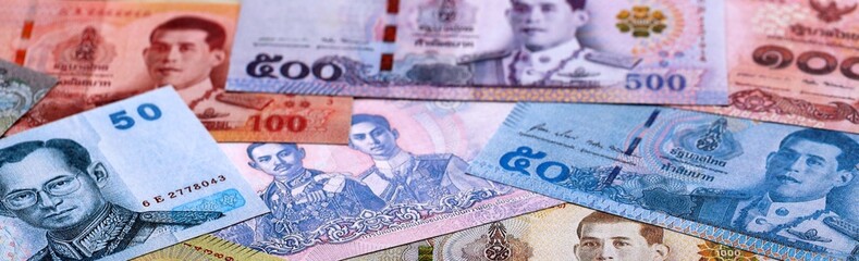 Thai baht money bills pile on table. Thailand banknotes of THB currency close up.
