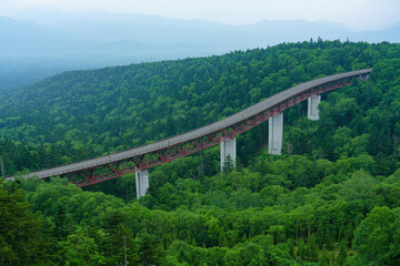 Fototapeta premium 北海道三国峠 松見大橋と大雪山の原生林に囲まれた山岳風景