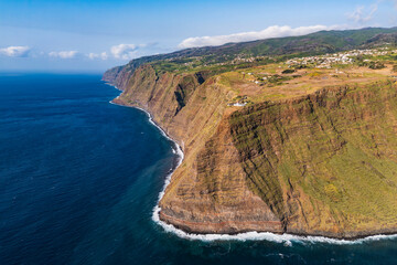 High volcanic cliffs with Ponta do Pargo lighthouse on the west coast of Madeira Island above the Atlantic Ocean, aerial view from drone © Leonid