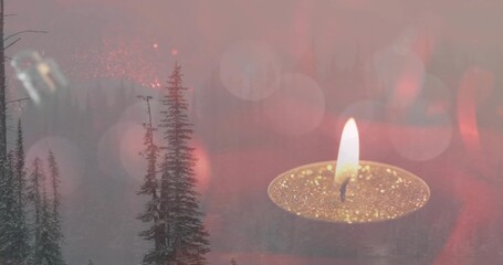 Glowing tealight candle in glitter gold cup flickering over misty evergreen trees, circular bokeh