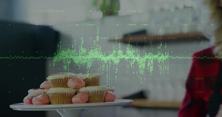 Showing cake stand holding pink cupcakes in kitchen, green wave overlay, plaid shirt, copy space © vectorfusionart